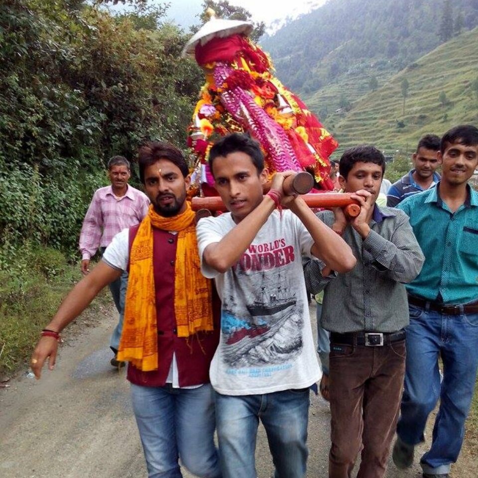 Pilgrims carry the decorated doli of goddess Nanda on a mountain road