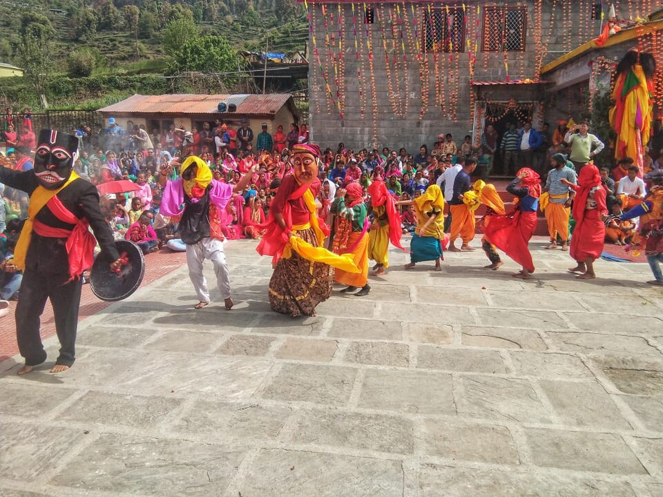 Masked Ramman performers dance in a temple courtyard at Saloor-Dungra