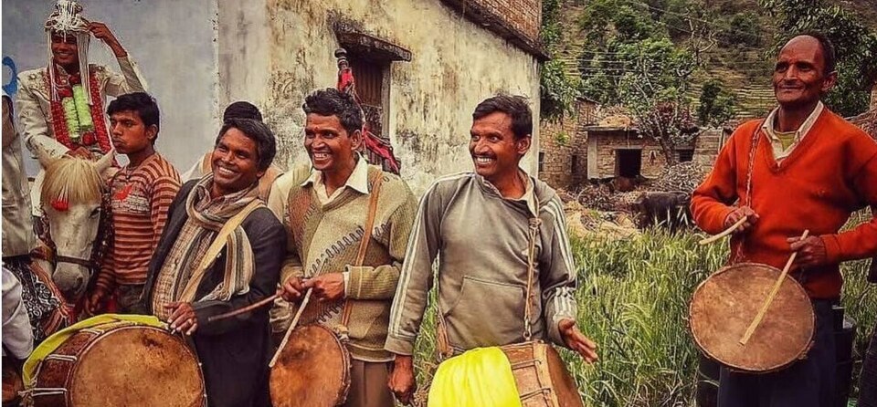 Village musicians with dhol and damau drums at a wedding procession